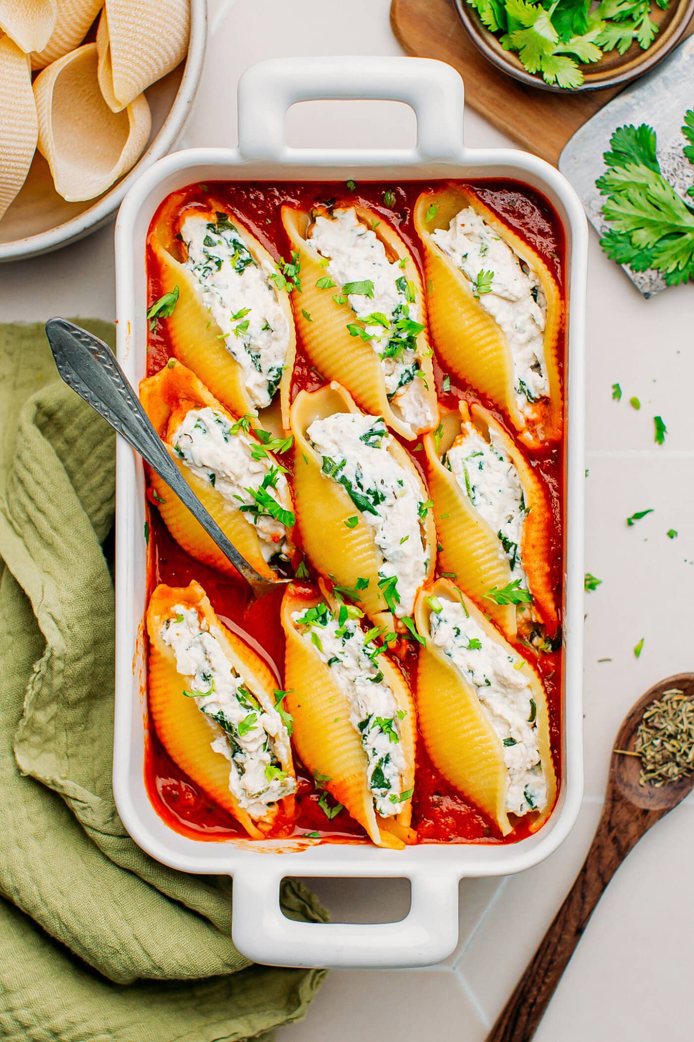 Stuffed shells with ricotta and  tomato sauce in a baking dish.