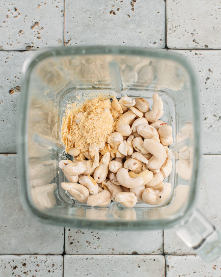 Raw cashews, nutritional yeast, and water in a blender.