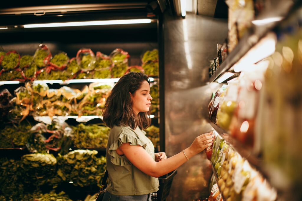 woman-grocery-shopping-in-an-aisle-with-food-that-has-nutrition-labels