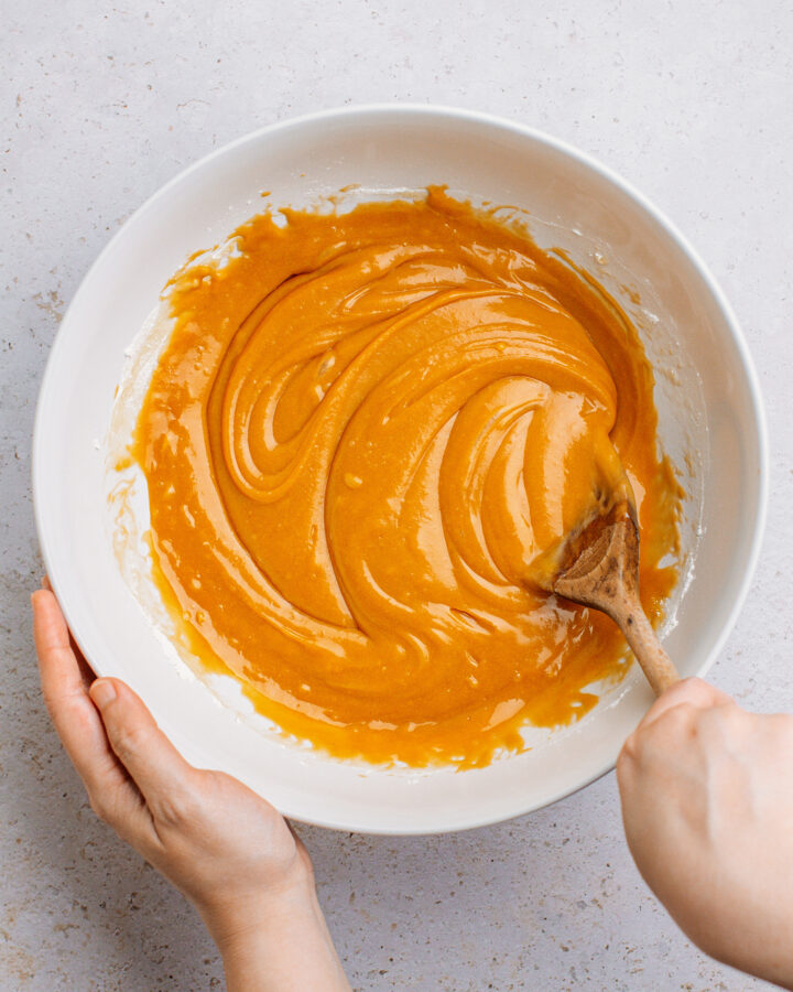 Sitrring caramel cake batter in a large mixing bowl.
