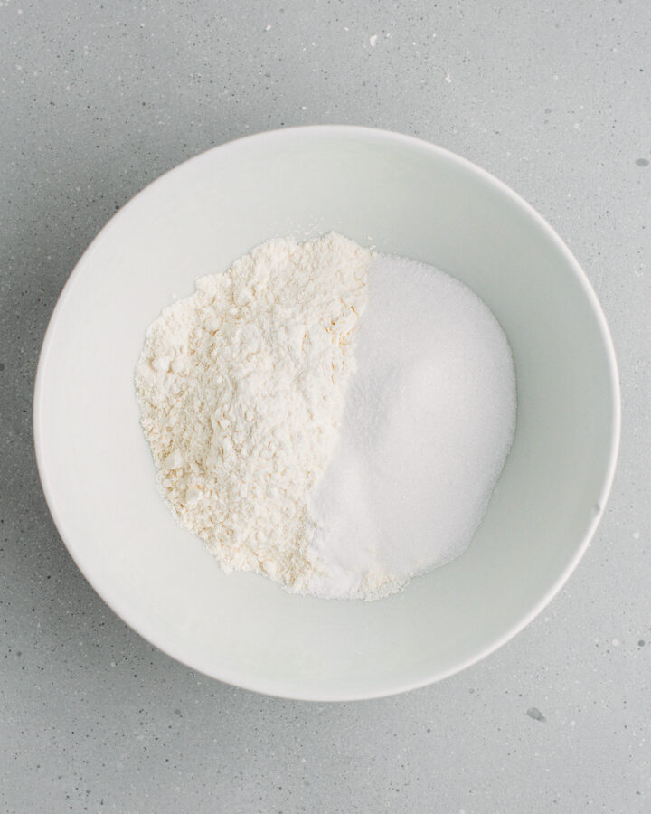 Flour, sugar, baking powder, and baking soda in a bowl.