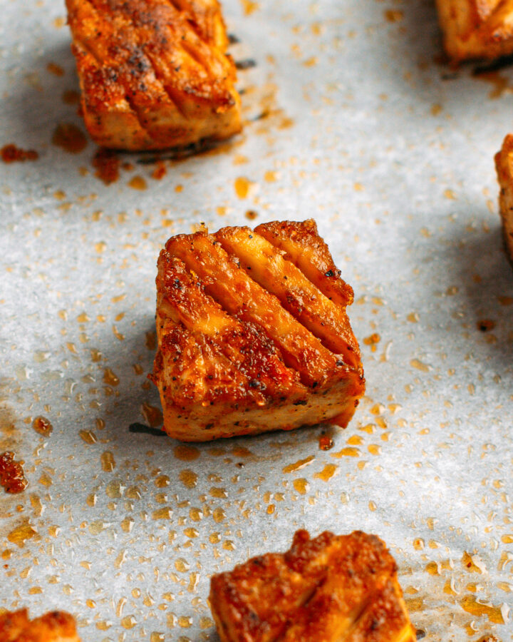 Close-up of a piece of baked tofu on a baking sheet.