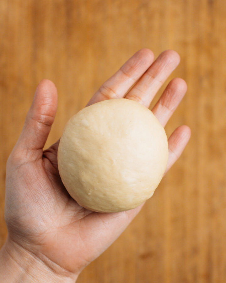 Holding a ball of brioche dough.