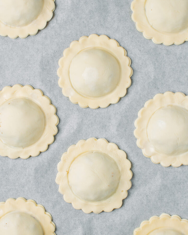 Vegan meat pastries on a baking sheet before baking.