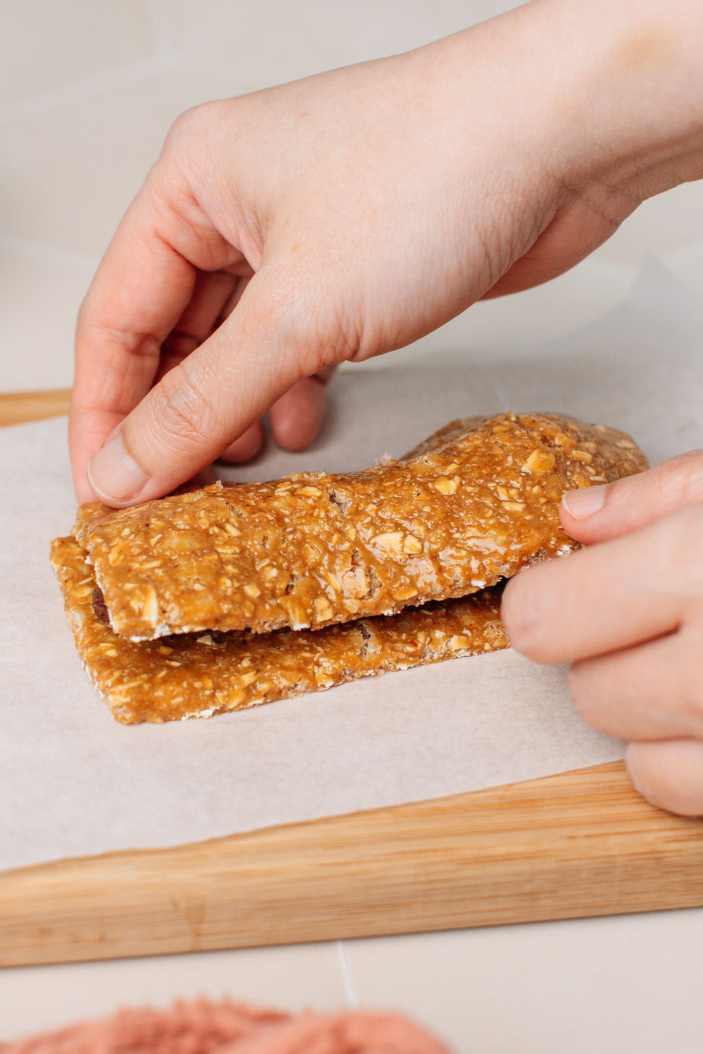 Placing a piece of granola bar on top of a chocolate filling. 