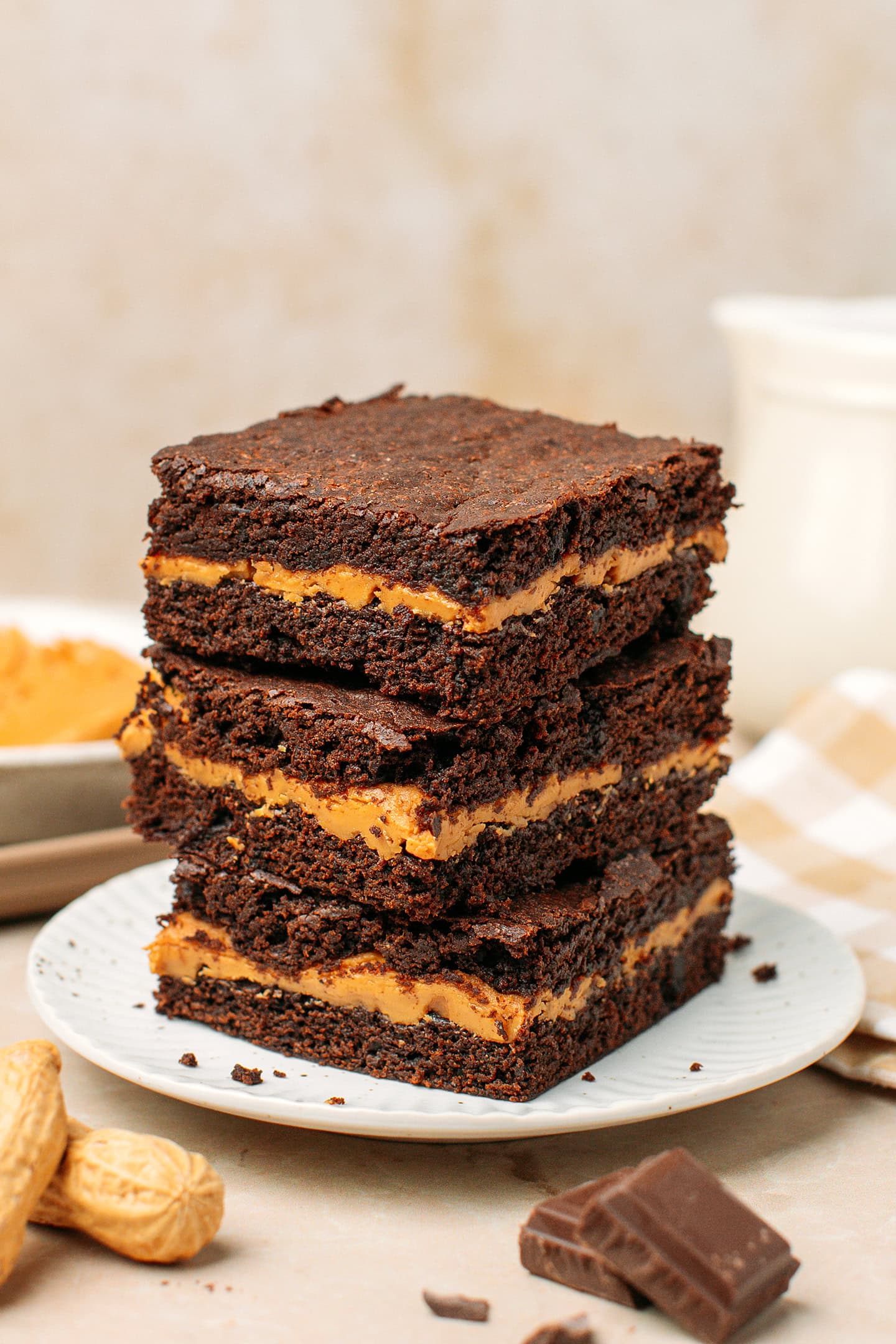 Three pieces of peanut butter brownies stacked on a small plate.