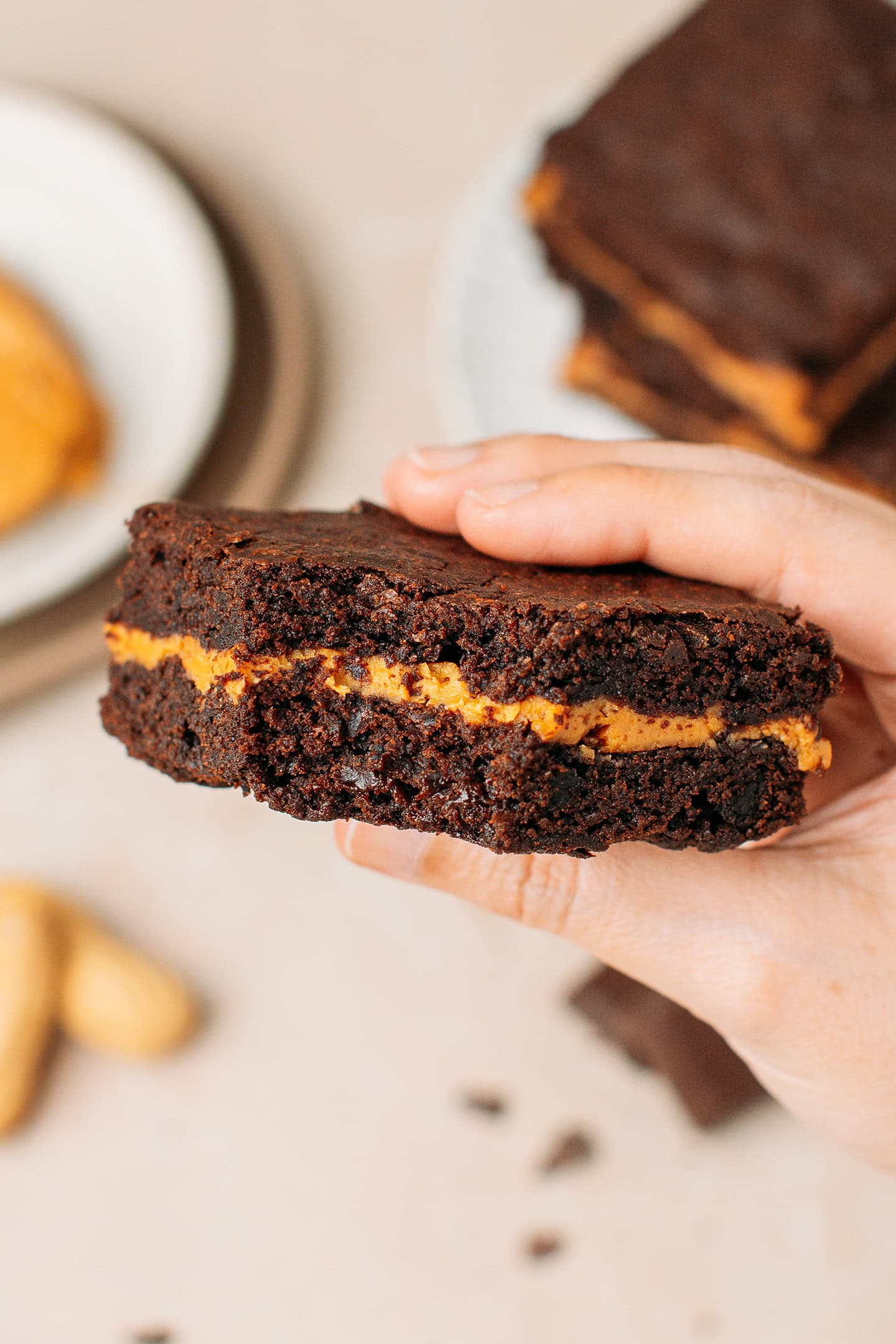 Holding a piece of brownie stuffed with peanut butter.