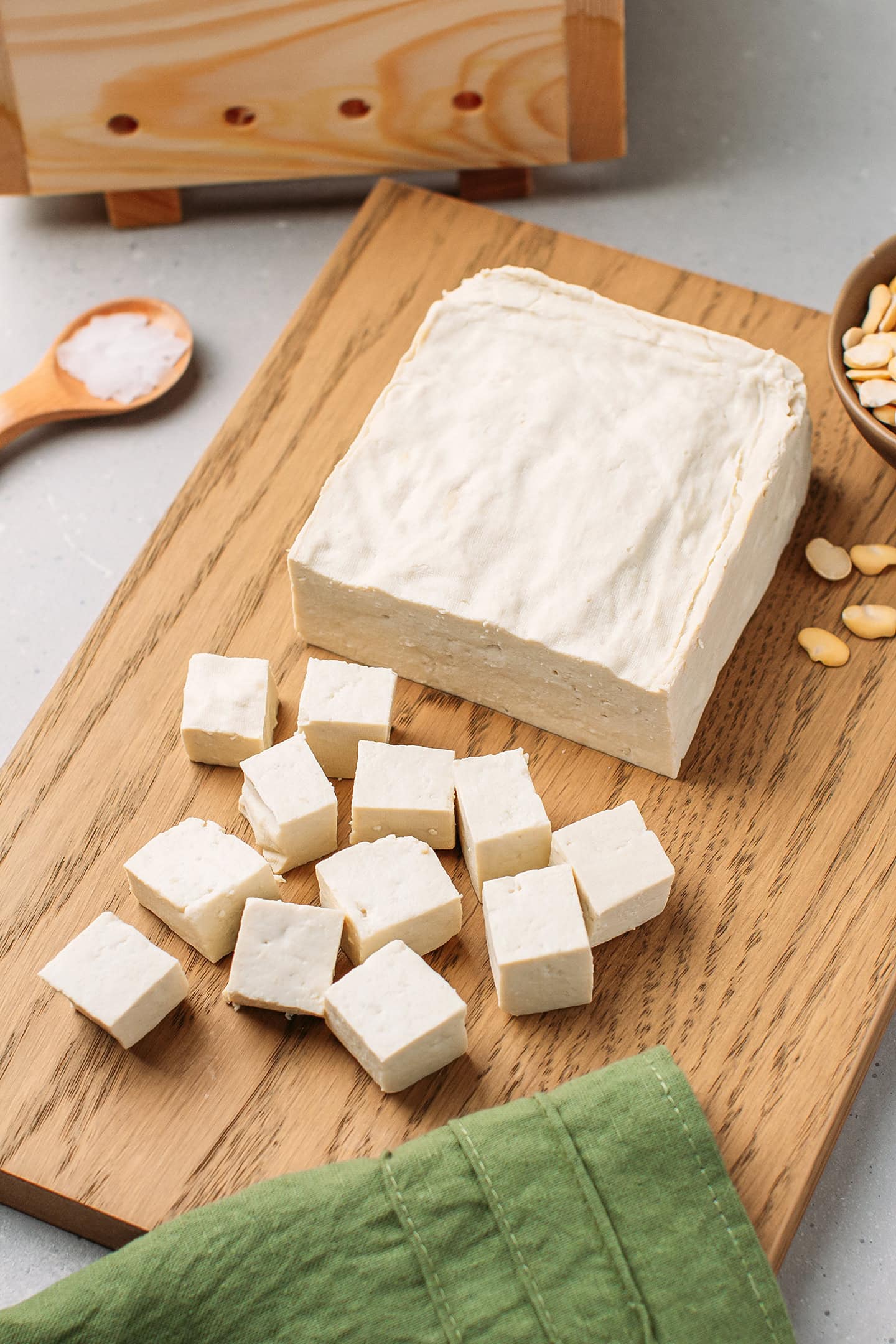 Block of fava bean tofu on a wooden board.